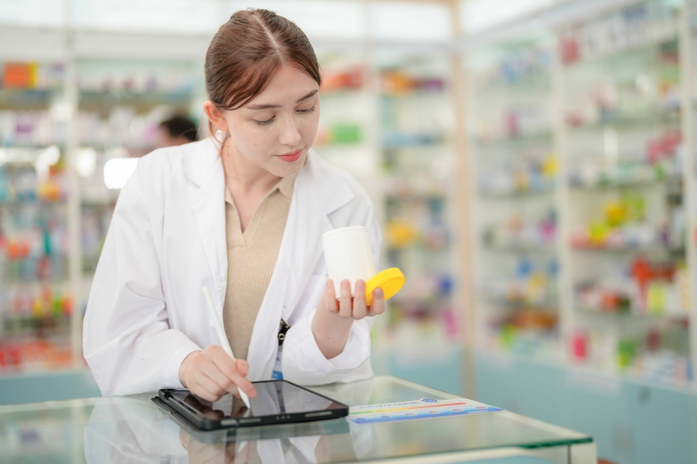 Una farmacéutica inspecciona un frasco de medicamento
