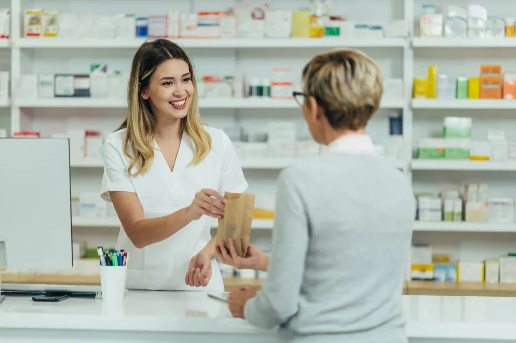 Pharmacist handing medication to a patient.