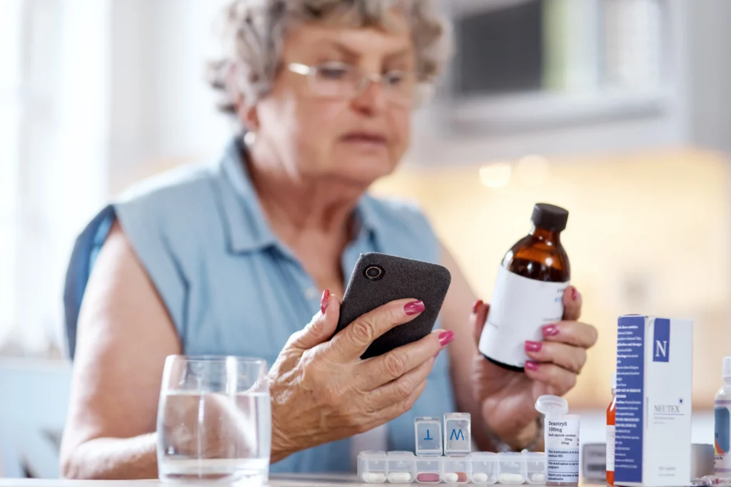 Senior woman using medication reminders and pill organizer