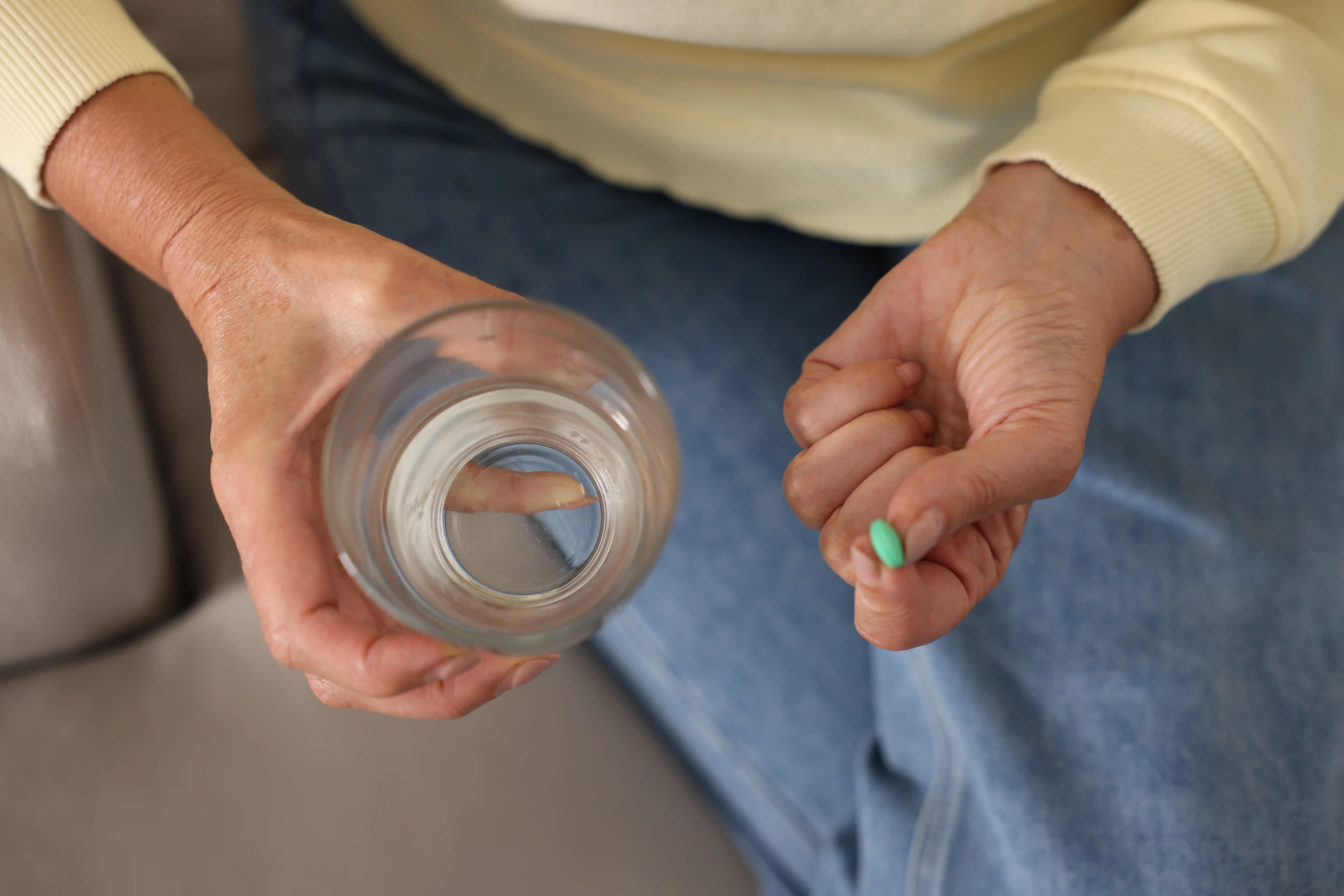 Woman holding a missed dose of Hydroxyzine and glass of water